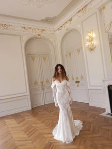 Indulge in the luxury of the Merryl Gown. This stunning mermaid gown features a sweetheart neckline adorned with draped satin, along with cold-shoulders and guipure sleeves for a sophisticated touch. The side satin panels and guipure bodice and skirt add a touch of modesty to this elegant piece.