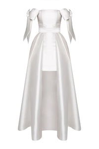 Crafted from luxurious silk and wool, the Margaret Dress offers a refined blend of texture and structure. Its innovative convertible design features a removable overskirt layered over a tailored midi pencil skirt, allowing for seamless transitions between sophisticated elegance and modern versatility. Ideal for those who appreciate expert craftsmanship and adaptable style.