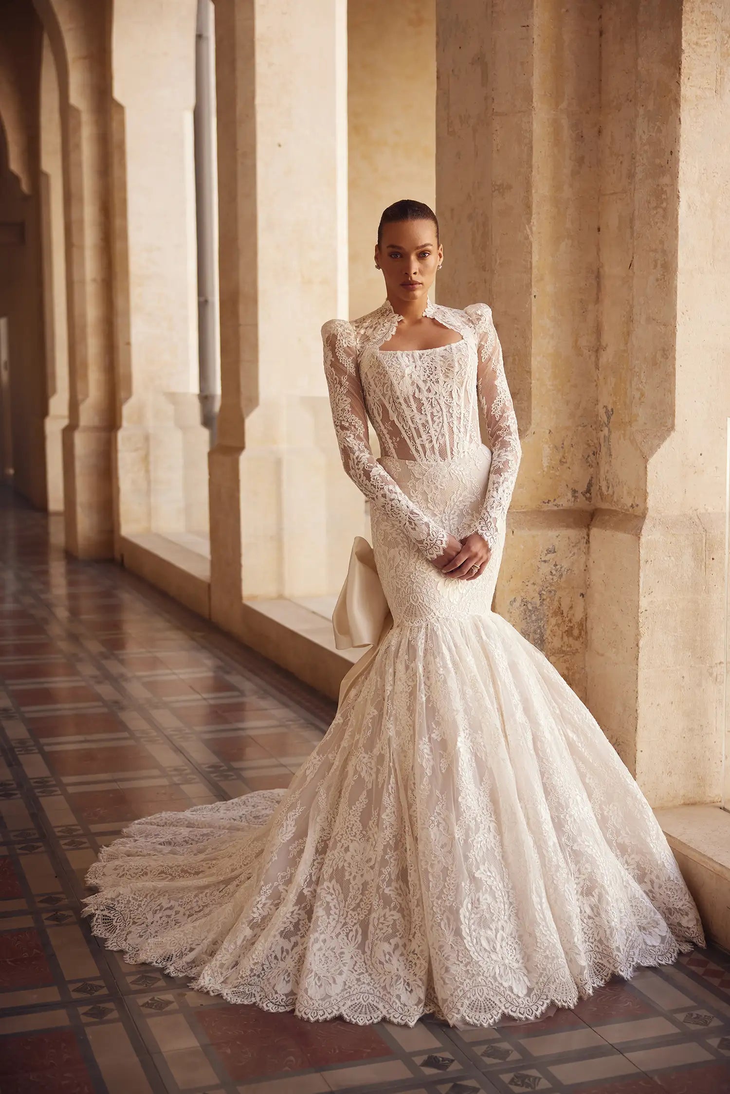 Feel like a true princess in our Melody Gown. The Alençon lace mermaid design and strapless scoop neckline will accentuate your figure, while the signature satin Pnina bow adds a touch of elegance. Complete your look with the coordinating lace bolero and matching gloves for the perfect fairytale wedding.