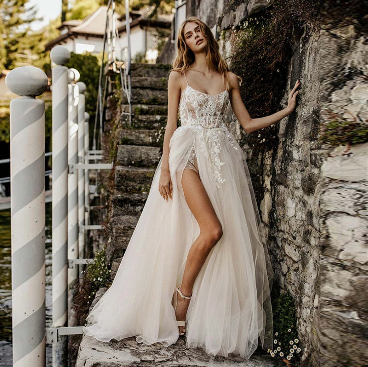 The Robe Aria is the perfect dress for bohemian brides. With a sexy sleeveless design and A-line silhouette, it features a side split and princess accents. Made for the free-spirited bride, this dress combines elegance and comfort for a truly enchanting wedding day.