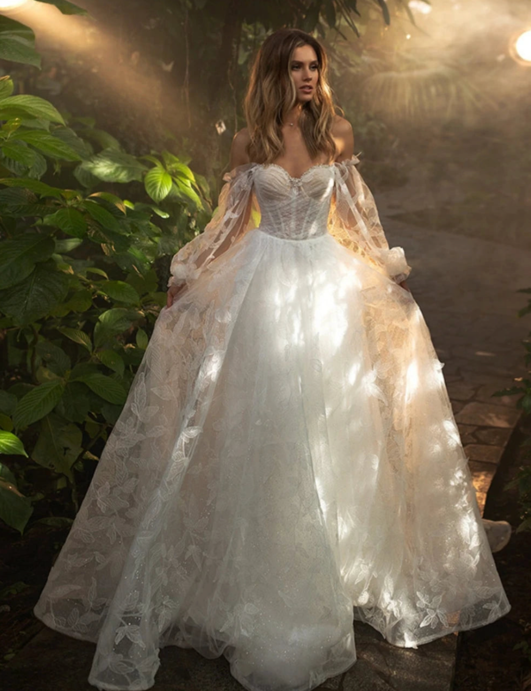 Indulge in the romantic elegance of our Robe Seva. With a sweetheart neckline and delicate lace appliques, this A-line wedding dress is the perfect balance of classic and modern. The sparkly details add a touch of glamour, making you the center of attention on your special day.
