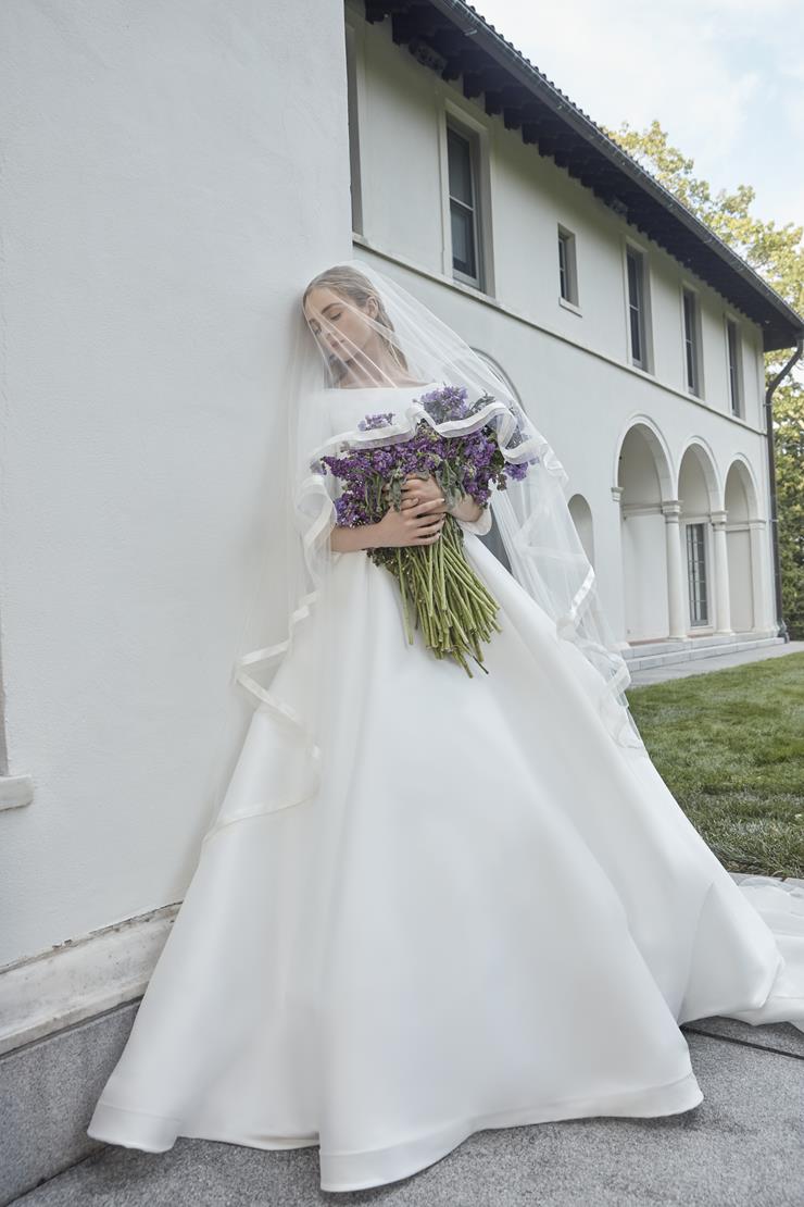 The Robe Magdalene is an elegant, a-line bridal gown fit for a princess. Its timeless design and flowing silhouette exude sophistication and grace. With its stunning appearance, this gown is perfect for any bride looking to make a statement on her special day.
