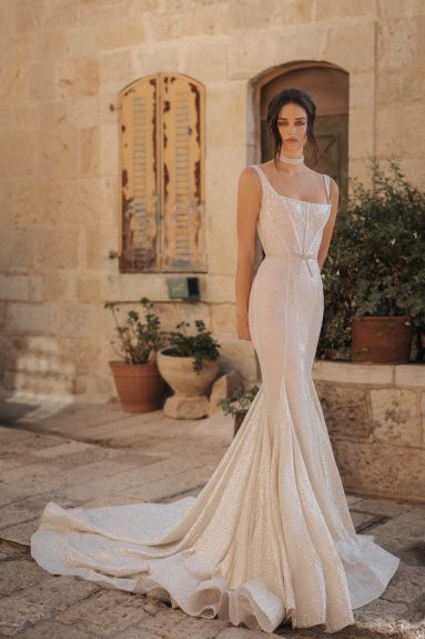 Be a blushing bride in the gorgeous Robe Emma! This stunning contemporary bridal gown features a flattering shiny mermaid design, perfect for making an unforgettable impression on your special day. Capture its beautiful essence and be the star of your own show! Get ready to shine!