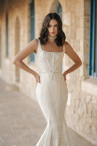 Be a blushing bride in the gorgeous Robe Emma! This stunning contemporary bridal gown features a flattering shiny mermaid design, perfect for making an unforgettable impression on your special day. Capture its beautiful essence and be the star of your own show! Get ready to shine!