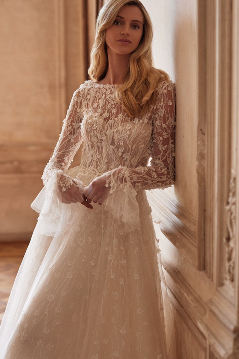 Experience elegance and style in Dress Evelyn. Featuring a detachable bodice, hidden zipper, and intricate lace and beadwork, this nude dress is perfect for any special occasion. The lace bolero with long sleeves and ruffled cuffs adds a touch of romance. Perfectly detailed with hand embroidered accents and 3D flowers.
