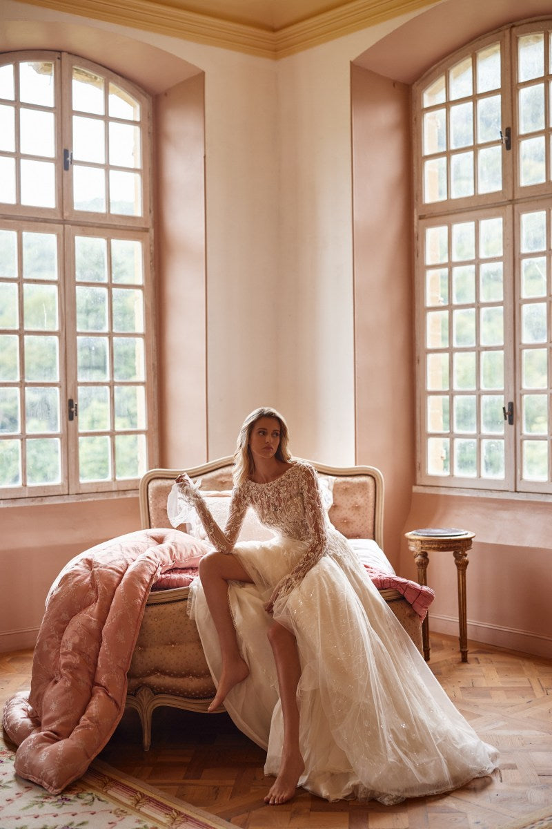 Experience elegance and style in Dress Evelyn. Featuring a detachable bodice, hidden zipper, and intricate lace and beadwork, this nude dress is perfect for any special occasion. The lace bolero with long sleeves and ruffled cuffs adds a touch of romance. Perfectly detailed with hand embroidered accents and 3D flowers.
