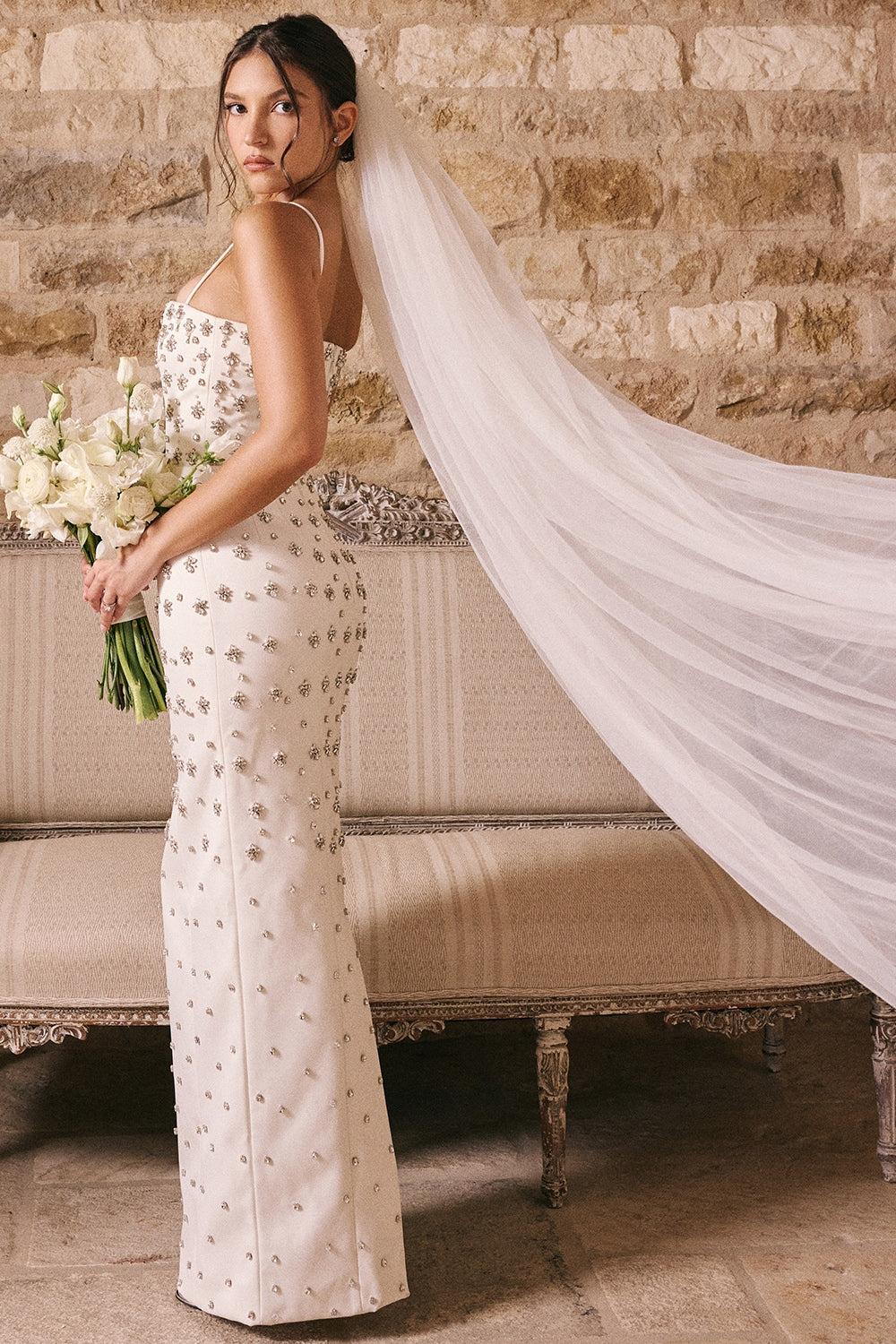 Robe Martine is hand embellished with details that will have you looking your most glamorous on your special day.&nbsp;The attention to detail is exquisite, as 'Martine' is beautifully embellished with faux pearls and silver crystals throughout. It's underpinned with our incredible corsetry boning to create a secure, structured fit to cinch your waist and it's finished by slender straps.
