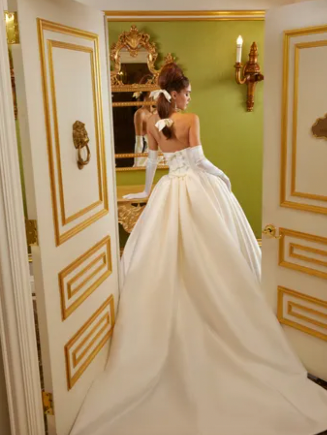 Luxurious and elegant, the Demia Gown is crafted from Italian Stretch Mikado fabric and features a cat eye neckline and basque waist for a flattering silhouette. The pleated and gathered ballgown is adorned with signature bow accents on the back bodice, making it a perfect pick for a special occasion.