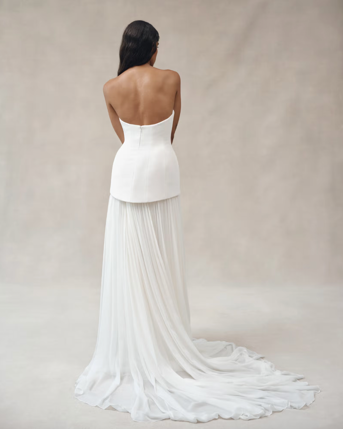 Experience luxury with the Clara Crepe Gown. Made from 100% satin silk crepe, this strapless gown offers a comfortable and elegant fit. The drop waist adds a touch of sophistication, making it the perfect choice for any special occasion. Available in a beautiful off-white color.