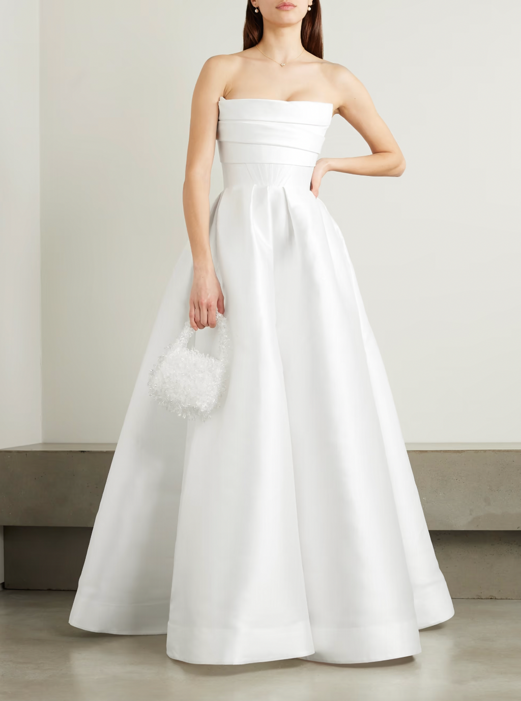 'Isobel' gown is such an elegant choice for your special day. Crafted from white satin-faille with a lustrous finish, it has the signature sculptural bodice and a full skirt with pleats that add structure and volume.