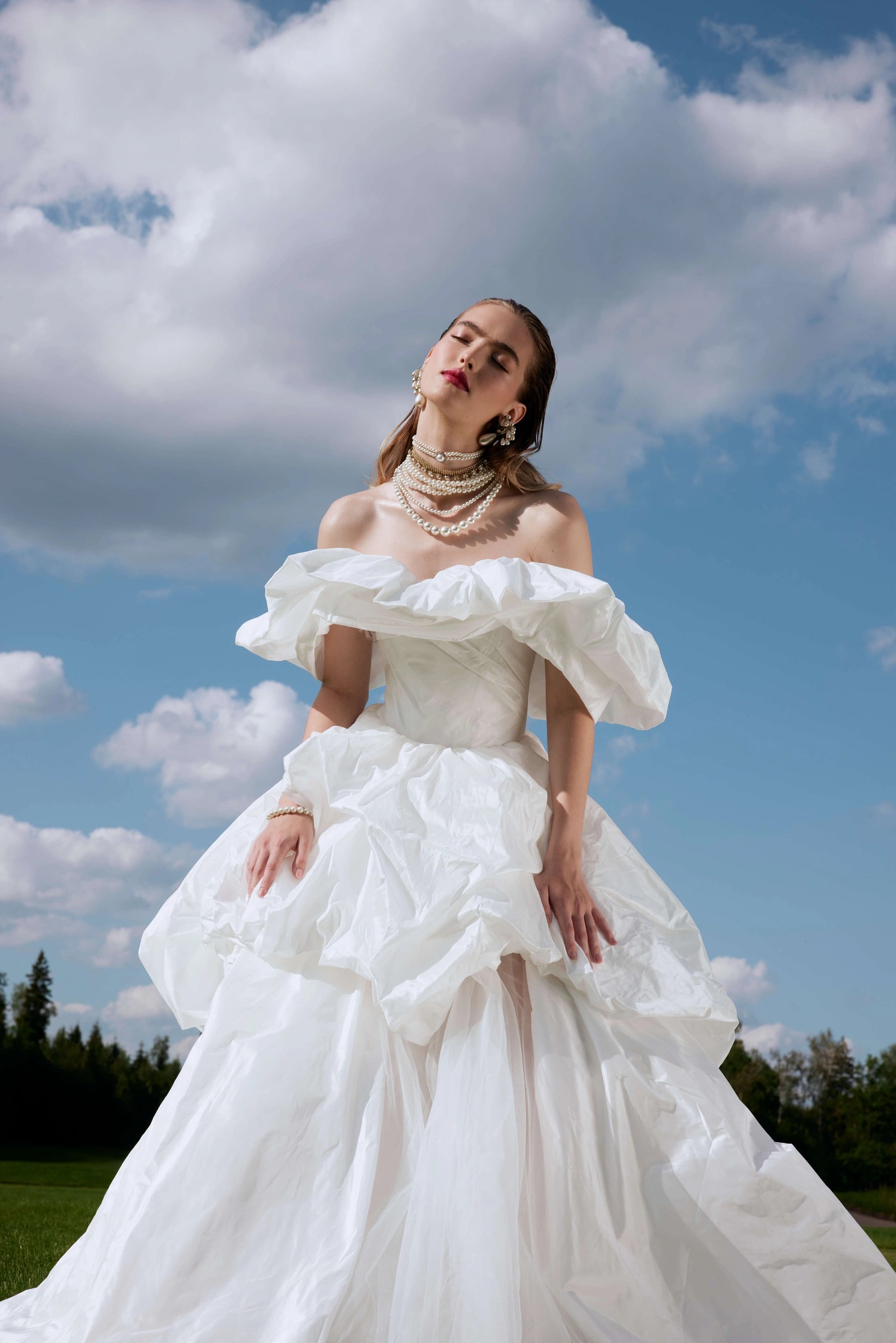 Elevate your special day with the Fenny Gown. This ball-gown silhouette wedding dress features voluminous dropped straps and a hook-back closure. Crafted with luxurious taffeta, it exudes elegance and sophistication. Say "I do" in style with the Fenny Gown.
