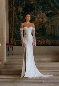 Effie is a luxurious fitted mermaid gown made of exclusive beaded lace. The off-shoulder neckline bares the collarbones adding seductiveness, the corset is decorated with sheer nude side pannels and long translucent lace sleeves look extravagant. The sheath skirt is embellished with thigh high slit and a Tulle overskirt is fastened on the waistline.