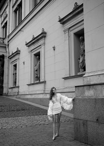 The Venice Mini Dress features a refined, short silhouette complemented by voluminous Venetian sleeves. Crafted entirely from handcrafted crinkled taffeta, it offers a unique texture that enhances its elegant appeal. Perfect for sophisticated occasions, this dress balances statement details with understated charm.