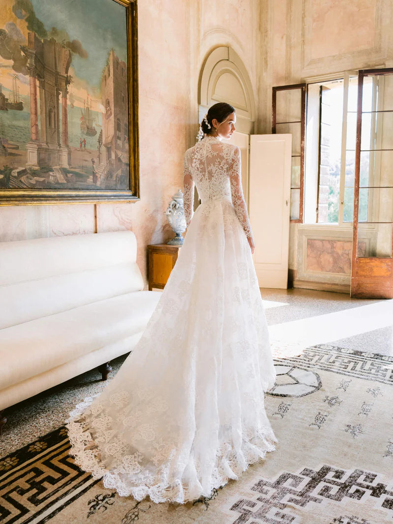 Experience the opulent Melrose Gown, a stunning garment crafted from premium lace and mesh. Its lace details and form-fitting bodice create a striking silhouette, while the voluminous skirt offers versatility for elegant and refined ensembles. In elegant ivory, this minimalistic design epitomizes exclusivity and sophistication.