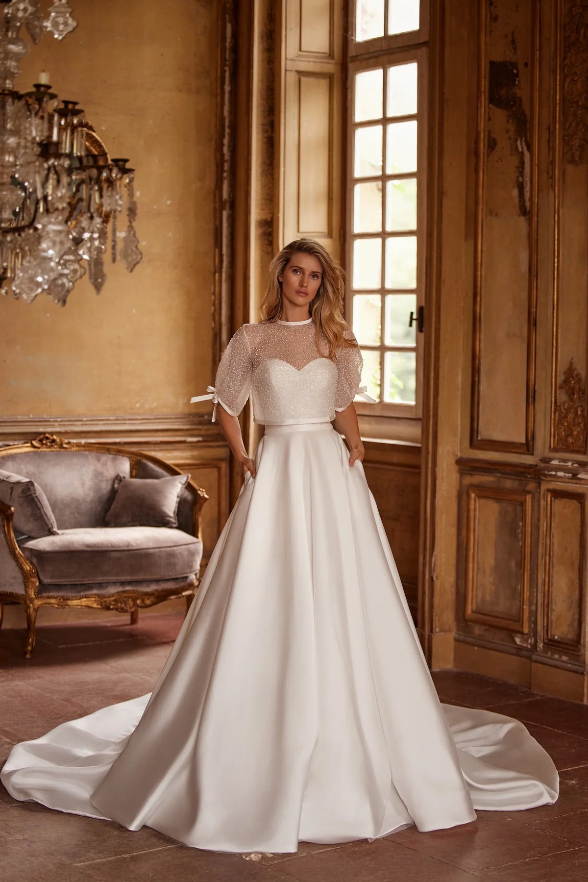 Elegant and timeless, the Ivory Mikado Robe Trudy is perfect for your special day. The structured corset, complete with a sweetheart neckline and internal lacing, ensures a flattering and secure fit. The flared skirt with pockets adds a modern touch to this classic wedding dress.