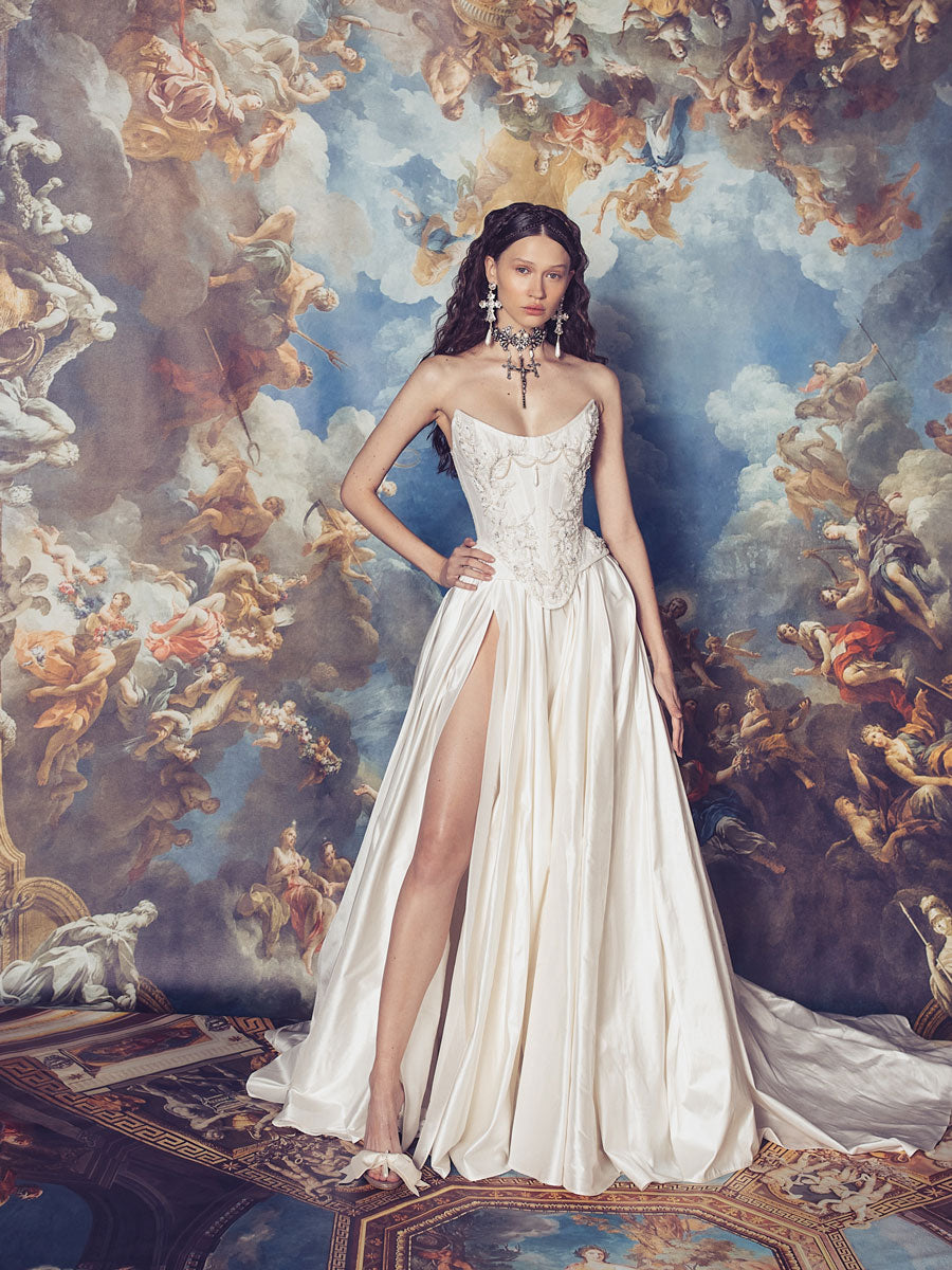Indulge in luxury with the Isabelle Gown. Crafted with a structured corset dress, this gown features intricate Indian embroidery on the bodice and a voluminous skirt. Made from high-quality silk taffeta, it exudes elegance and sophistication, making it the perfect choice for any formal occasion. The thigh high slit adds a touch of allure to this stunning gown.