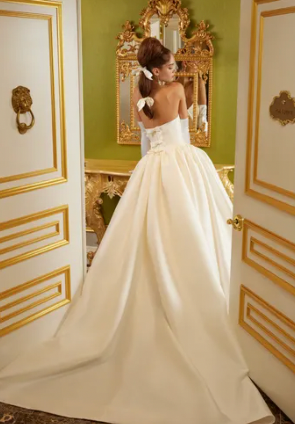 Luxurious and elegant, the Demia Gown is crafted from Italian Stretch Mikado fabric and features a cat eye neckline and basque waist for a flattering silhouette. The pleated and gathered ballgown is adorned with signature bow accents on the back bodice, making it a perfect pick for a special occasion.