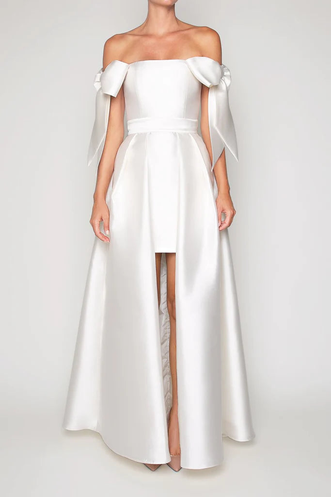 Crafted from luxurious silk and wool, the Margaret Dress offers a refined blend of texture and structure. Its innovative convertible design features a removable overskirt layered over a tailored midi pencil skirt, allowing for seamless transitions between sophisticated elegance and modern versatility. Ideal for those who appreciate expert craftsmanship and adaptable style.