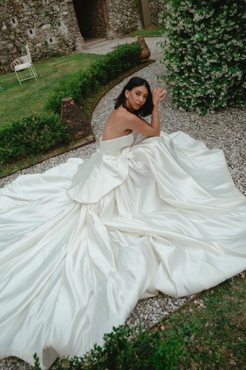 Get ready to walk down the aisle in style with our Romina Gown! This vintage-inspired wedding dress features a stunning backless design, elegant puff sleeves, and a flattering A-line silhouette. Made with soft, stain-resistant fabric, it's the perfect choice for your big day.