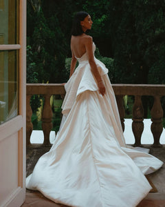 Get ready to walk down the aisle in style with our Romina Gown! This vintage-inspired wedding dress features a stunning backless design, elegant puff sleeves, and a flattering A-line silhouette. Made with soft, stain-resistant fabric, it's the perfect choice for your big day.