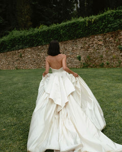 Get ready to walk down the aisle in style with our Romina Gown! This vintage-inspired wedding dress features a stunning backless design, elegant puff sleeves, and a flattering A-line silhouette. Made with soft, stain-resistant fabric, it's the perfect choice for your big day.