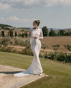 Step out in style with our Robe Emmeline. This stunning fitted gown is adorned with delicate embellishments, giving you a touch of elegance for any special occasion. The long bell sleeves and dramatic low back will make heads turn, while the waist-cinching detail adds a flattering touch. Feel confident and glamorous in the Emmeline Bridal Dress.