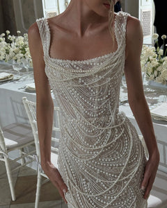 Get ready to dazzle on your special day with the Versy Gown. The fitted silhouette is enhanced by a relief corset made of transparent mesh and lace, adorned with asymmetrical pearl threads. The whimsical silhouette skirt features scattered pearl threads and removable stars for a unique, ethereal touch. Say "I do" in style with the Versy Gown.