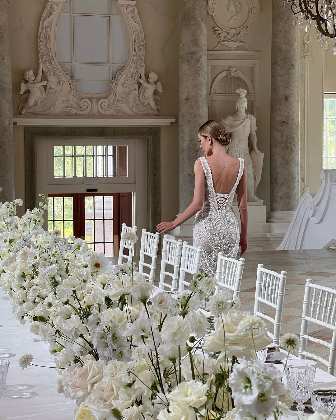 Get ready to dazzle on your special day with the Versy Gown. The fitted silhouette is enhanced by a relief corset made of transparent mesh and lace, adorned with asymmetrical pearl threads. The whimsical silhouette skirt features scattered pearl threads and removable stars for a unique, ethereal touch. Say "I do" in style with the Versy Gown.
