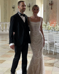 Get ready to dazzle on your special day with the Versy Gown. The fitted silhouette is enhanced by a relief corset made of transparent mesh and lace, adorned with asymmetrical pearl threads. The whimsical silhouette skirt features scattered pearl threads and removable stars for a unique, ethereal touch. Say "I do" in style with the Versy Gown.