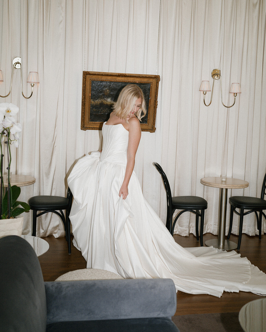 Indulge in the luxurious Arisa Gown: an exquisite dress featuring a minimalist design and made with high-quality fabrics like satin and mesh. The corset's off-shoulder straps create a stunning silhouette, while the versatile fitted and voluminous skirts allow for two elegant and sophisticated styles. In elegant ivory color.