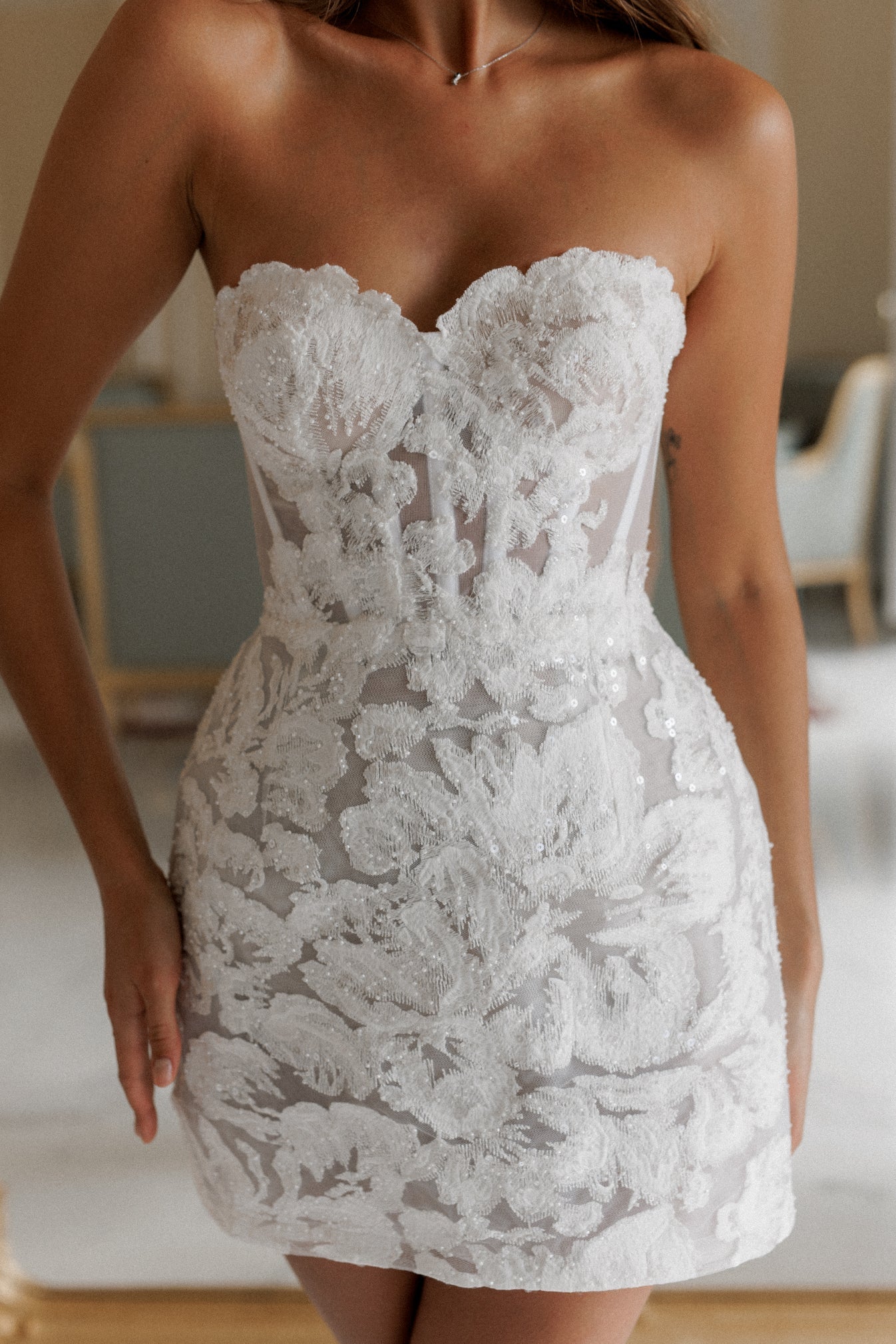 Elevate your bridal style with Isabelli Mini Dress, featuring A-line silhouette and exquisite details. The beautifully embroidered lace and subtle beads add a touch of elegance to the structured boning for a flawless fit. Perfect for the modern bride, exuding sophistication and grace.