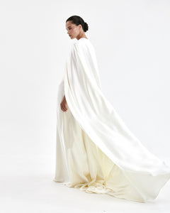 A laconic cape with a smooth texture — a luxurious attribute of the image that emphasizes the elegance and inner strength of its owner. The soft overflow of the fabric, the exquisite silhouette and train make the product expressive and self-sufficient. The composition was chosen consciously: the material does not wrinkle, retains its shape and provides an impeccable appearance throughout the evening. Becomes the final chord in a special event without requiring additional details. 