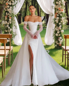 Effie is a luxurious fitted mermaid gown made of exclusive beaded lace. The off-shoulder neckline bares the collarbones adding seductiveness, the corset is decorated with sheer nude side pannels and long translucent lace sleeves look extravagant. The sheath skirt is embellished with thigh high slit and a Tulle overskirt is fastened on the waistline.