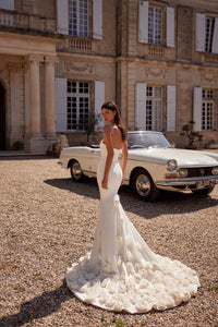 The Robe Clementine is the perfect choice for a glamorous and sophisticated wedding. Made from elastic satin fabric, this mermaid dress features a corset with a heart-shaped neckline and bare shoulders to accentuate your natural beauty. The internal lacing and zipper closure provide a perfect fit while the exquisite handmade flowers add a touch of elegance and boldness to the look.