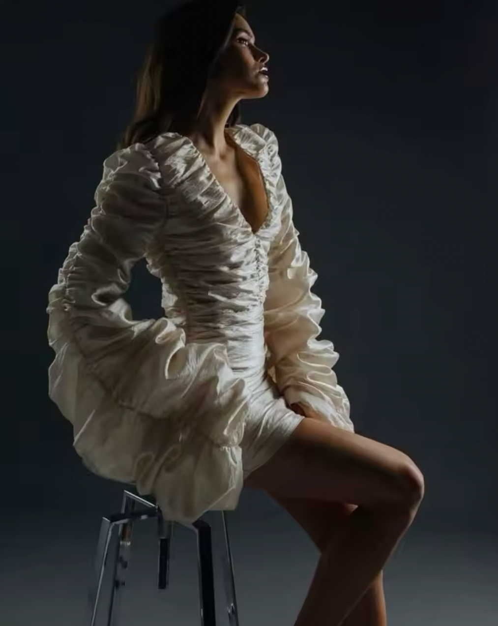 The Venice Mini Dress features a refined, short silhouette complemented by voluminous Venetian sleeves. Crafted entirely from handcrafted crinkled taffeta, it offers a unique texture that enhances its elegant appeal. Perfect for sophisticated occasions, this dress balances statement details with understated charm.