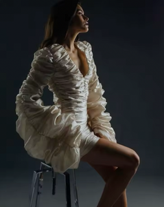 The Venice Mini Dress features a refined, short silhouette complemented by voluminous Venetian sleeves. Crafted entirely from handcrafted crinkled taffeta, it offers a unique texture that enhances its elegant appeal. Perfect for sophisticated occasions, this dress balances statement details with understated charm.