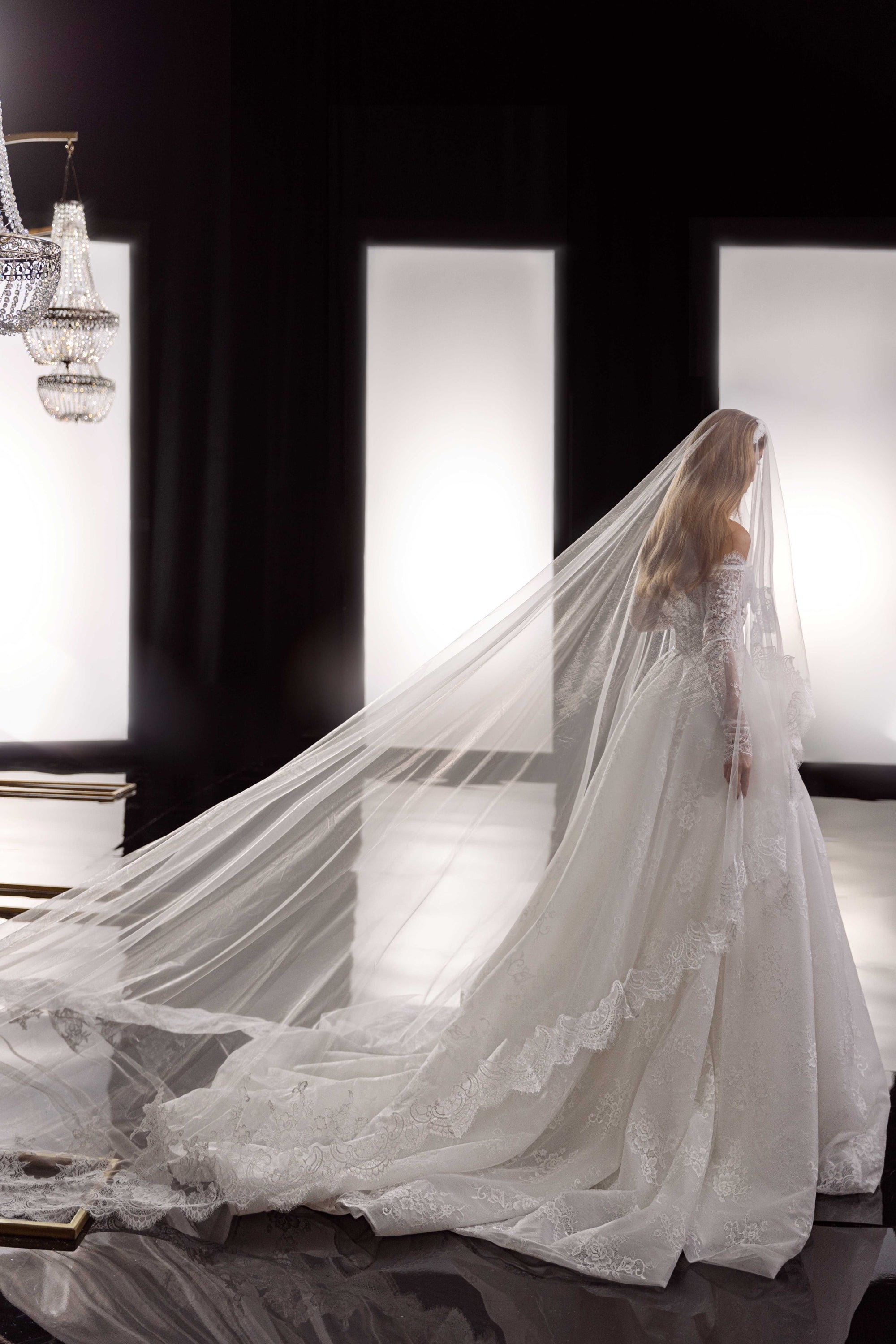 This Bernita Gown exudes elegance with its exquisite French lace and romantic allure. The accompanying veil adds a touch of chic and completes the bridal look. Perfect for any sophisticated bride seeking a timeless and refined wedding gown.