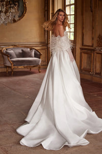 Elegant and timeless, the Ivory Mikado Robe Trudy is perfect for your special day. The structured corset, complete with a sweetheart neckline and internal lacing, ensures a flattering and secure fit. The flared skirt with pockets adds a modern touch to this classic wedding dress.