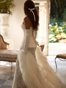 Experience the regal elegance and timeless grace of the Joely Gown. Featuring a flattering sweet-heart neckline and hidden boning, this gown creates a structured fit that elongates the silhouette and defines the waist. The lace-up back closure adds a touch of luxury, while the matching skirt completes the bridal look.
