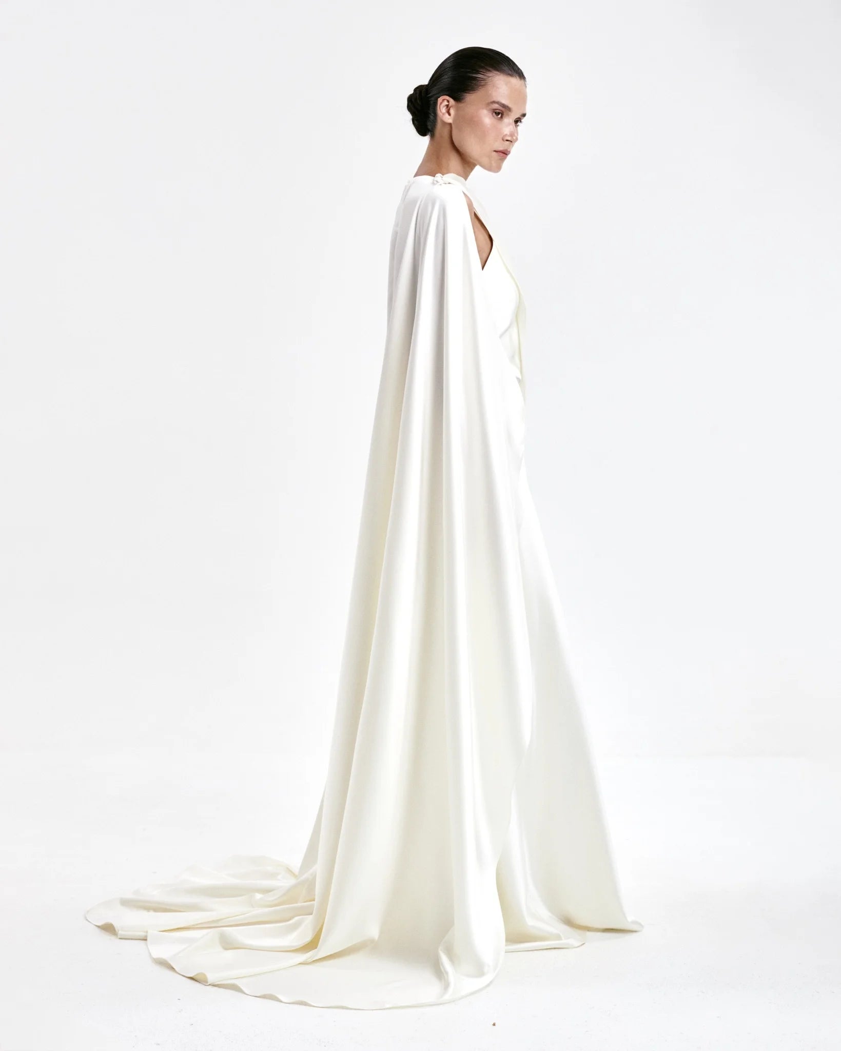 A laconic cape with a smooth texture — a luxurious attribute of the image that emphasizes the elegance and inner strength of its owner. The soft overflow of the fabric, the exquisite silhouette and train make the product expressive and self-sufficient. The composition was chosen consciously: the material does not wrinkle, retains its shape and provides an impeccable appearance throughout the evening. Becomes the final chord in a special event without requiring additional details. 