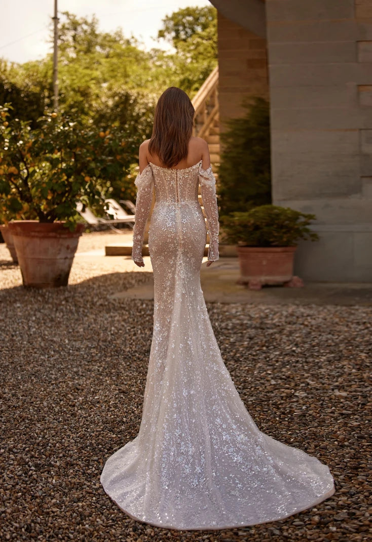 The Willow Dress is a stunning choice for your special day. The mermaid silhouette highlights the curves of the body, and the semi-transparent corset with lace and embroidered sequins adds a touch of elegance. With a heart-shaped neckline and delicate milky shine, this dress will make you feel both seductive and beautiful on your special day.