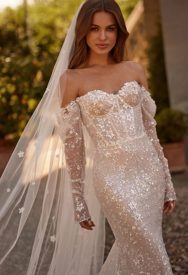 The Willow Dress is a stunning choice for your special day. The mermaid silhouette highlights the curves of the body, and the semi-transparent corset with lace and embroidered sequins adds a touch of elegance. With a heart-shaped neckline and delicate milky shine, this dress will make you feel both seductive and beautiful on your special day.