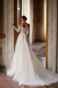 Introducing the Regina Gown, a light skin A-line dress that will make any bride the star of the wedding. The semi-sheer corset with a deep heart cutout and embroidered lace patterns adds a seductive touch, while the fluffy skirt and luxurious train create a stunning silhouette. Available in ivory.