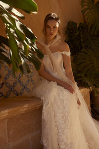Channel your inner risk-taker on your big day with the one-of-a-kind Blossom Gown. Featuring delicate lace appliques that flow down the skirt and complete the train, this dress is perfect for the adventurous bride. The detachable straps add an extra touch of uniqueness to this bold and beautiful gown.