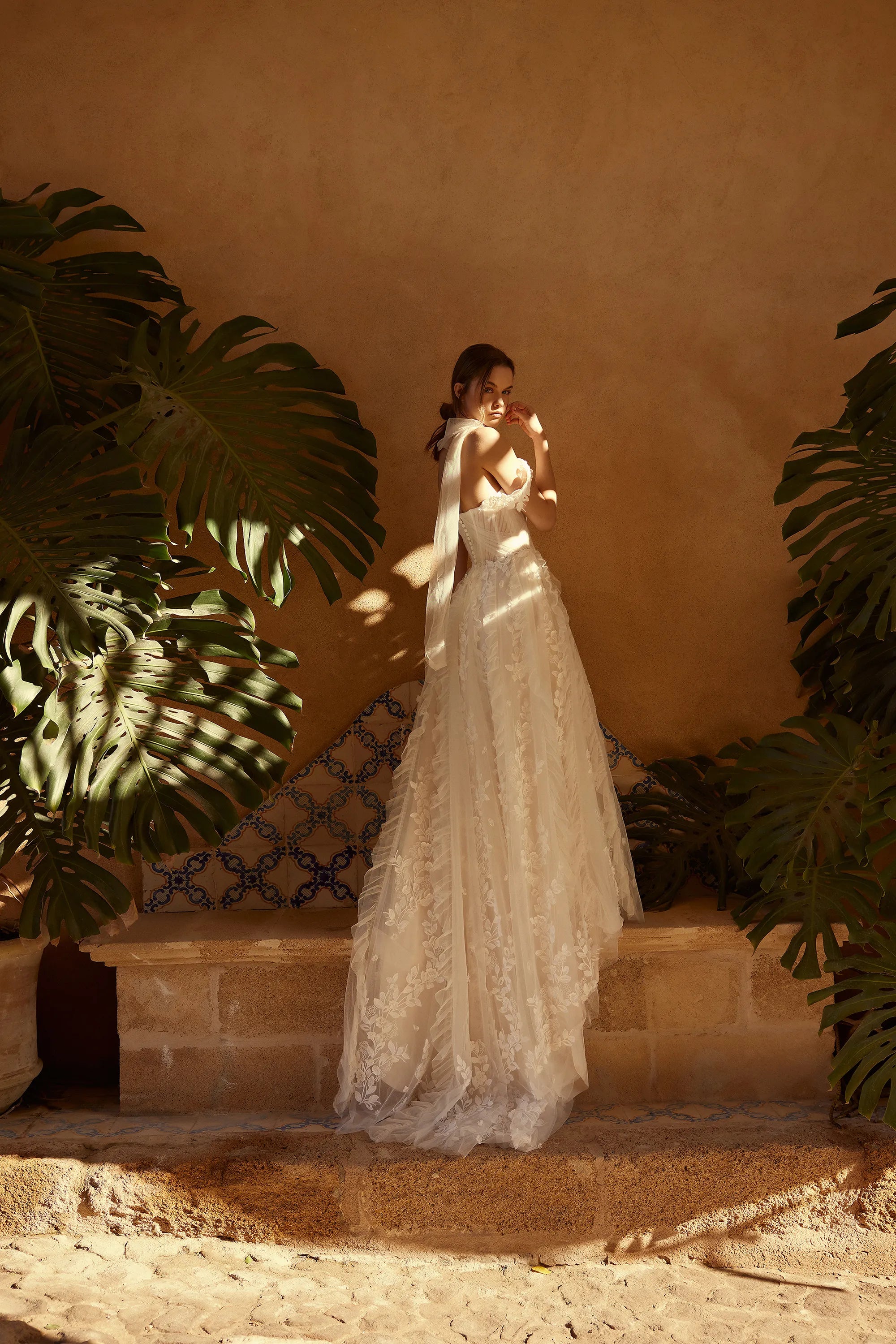 Channel your inner risk-taker on your big day with the one-of-a-kind Blossom Gown. Featuring delicate lace appliques that flow down the skirt and complete the train, this dress is perfect for the adventurous bride. The detachable straps add an extra touch of uniqueness to this bold and beautiful gown.