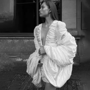 The Venice Mini Dress features a refined, short silhouette complemented by voluminous Venetian sleeves. Crafted entirely from handcrafted crinkled taffeta, it offers a unique texture that enhances its elegant appeal. Perfect for sophisticated occasions, this dress balances statement details with understated charm.