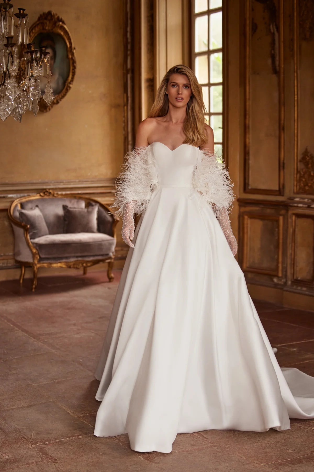 Elegant and timeless, the Ivory Mikado Robe Trudy is perfect for your special day. The structured corset, complete with a sweetheart neckline and internal lacing, ensures a flattering and secure fit. The flared skirt with pockets adds a modern touch to this classic wedding dress.