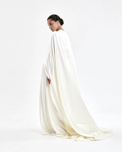 A laconic cape with a smooth texture — a luxurious attribute of the image that emphasizes the elegance and inner strength of its owner. The soft overflow of the fabric, the exquisite silhouette and train make the product expressive and self-sufficient. The composition was chosen consciously: the material does not wrinkle, retains its shape and provides an impeccable appearance throughout the evening. Becomes the final chord in a special event without requiring additional details. 