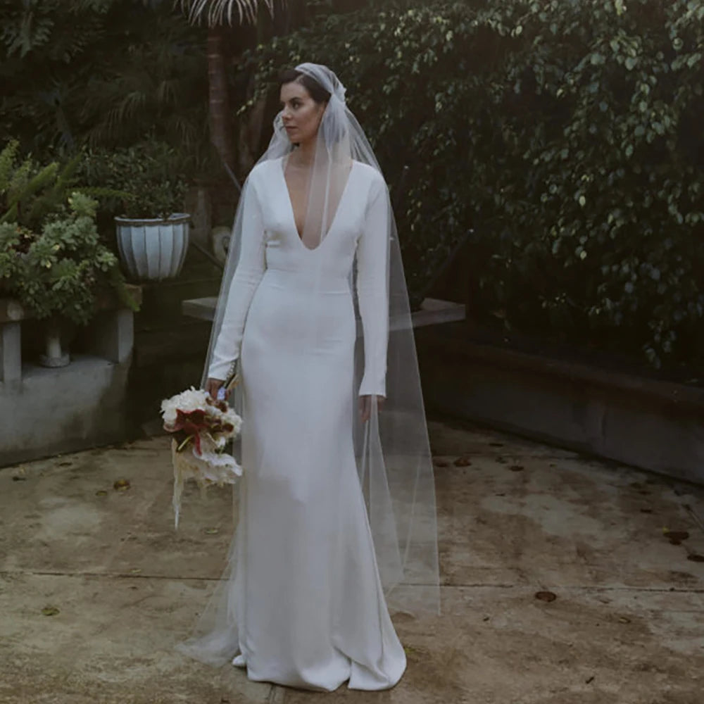 Robe Zelie is a one-of-a-kind custom made bridal gown. Featuring a luxe deep V-neckline, long fitted sleeves, and an A-line crepe skirt with a closed back zipper, this elegant wedding dress is perfect for plus size brides. The perfect balance of style and comfort, Robe Zelie is a sure show-stopper.
