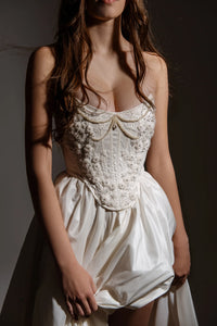 Indulge in elegance and comfort with the Katherine Gown. Adorned with exquisite beaded appliqués, the taffeta corset ensures a flawless fit, while the lined leg slit skirt adds a touch of refinement. Step out in style and radiate beauty with each stride.